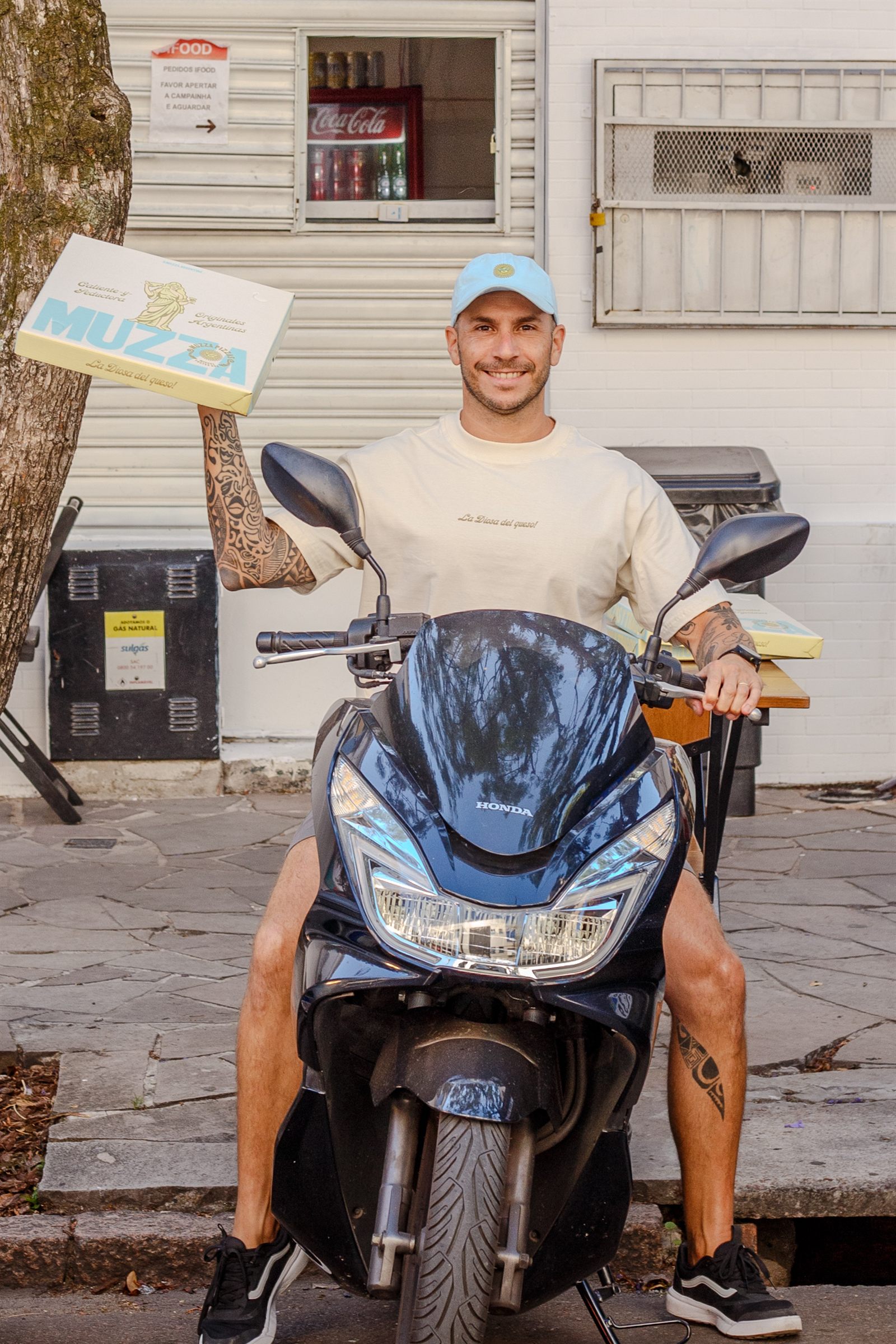 Delivery próprio Muzza — moto na rua de Porto Alegre